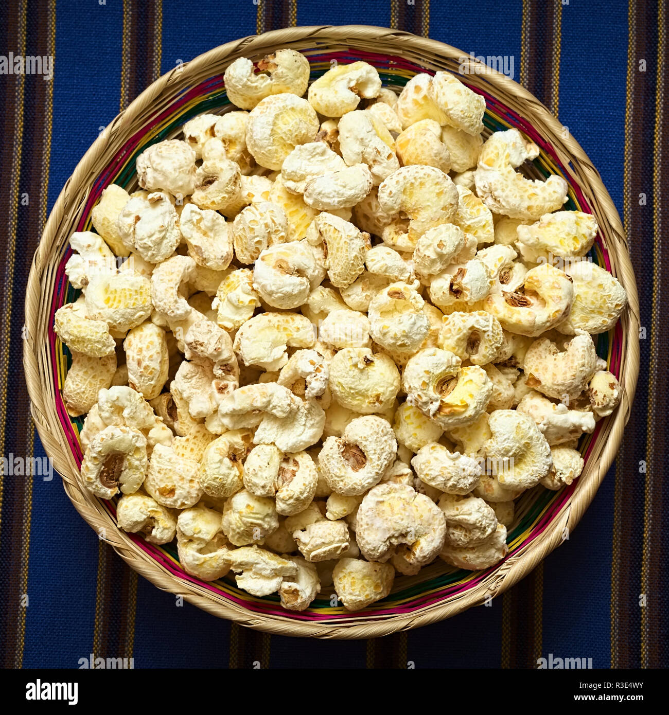 Gesüßt knallte weißer Mais namens Pasancalla gegessen als Snack in Bolivien in einem geflochtenen Korb serviert, mit natürlichem Licht fotografiert. Stockfoto