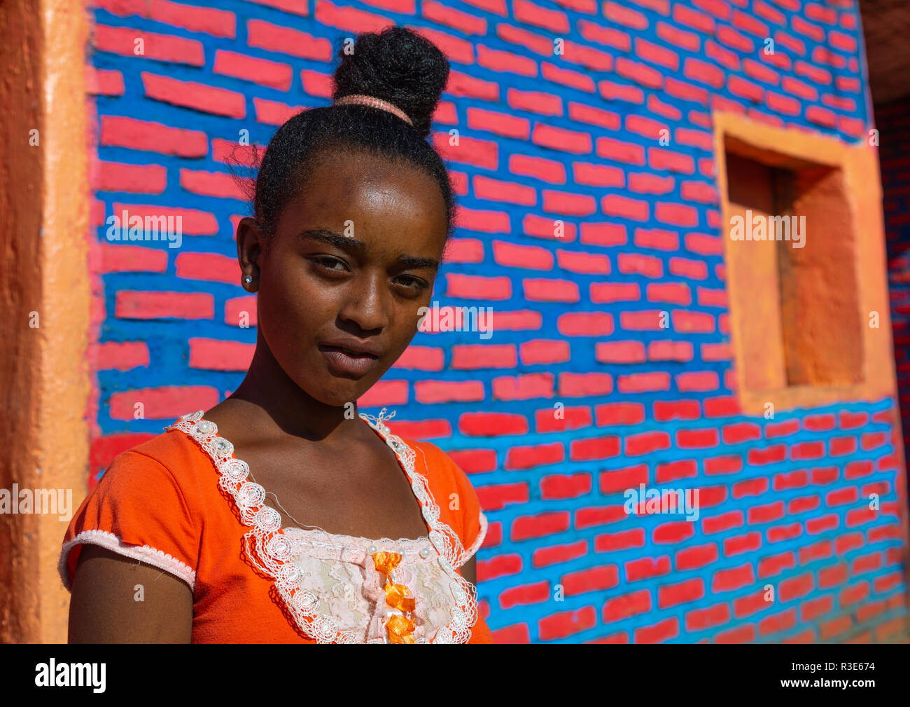 Äthiopische Frau stand vor der bunten Mauer, Sitzbank Maji, Mizan Teferi, Äthiopien Stockfoto