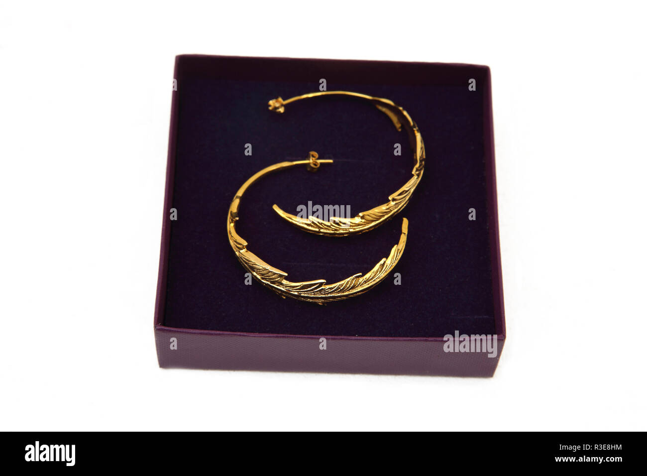 Die Hälfte Gold Hoop Ohrhänger mit Blatt Design Stockfoto