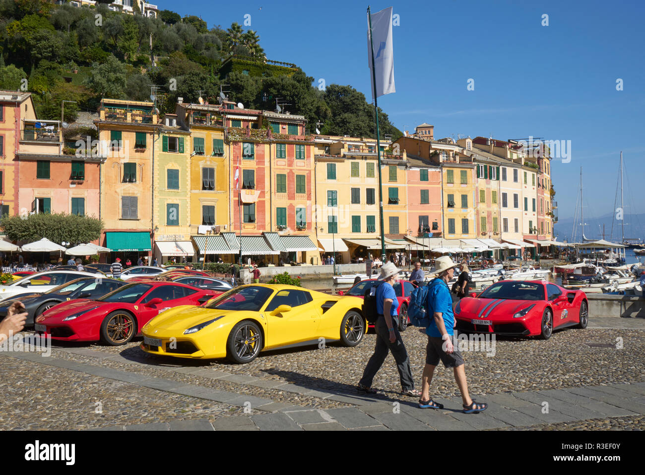 Portofino, Ligurien, Italien: Ferrari Anzeige im Hafen mit Touristen in Hüte und blauen Shirts Stockfoto
