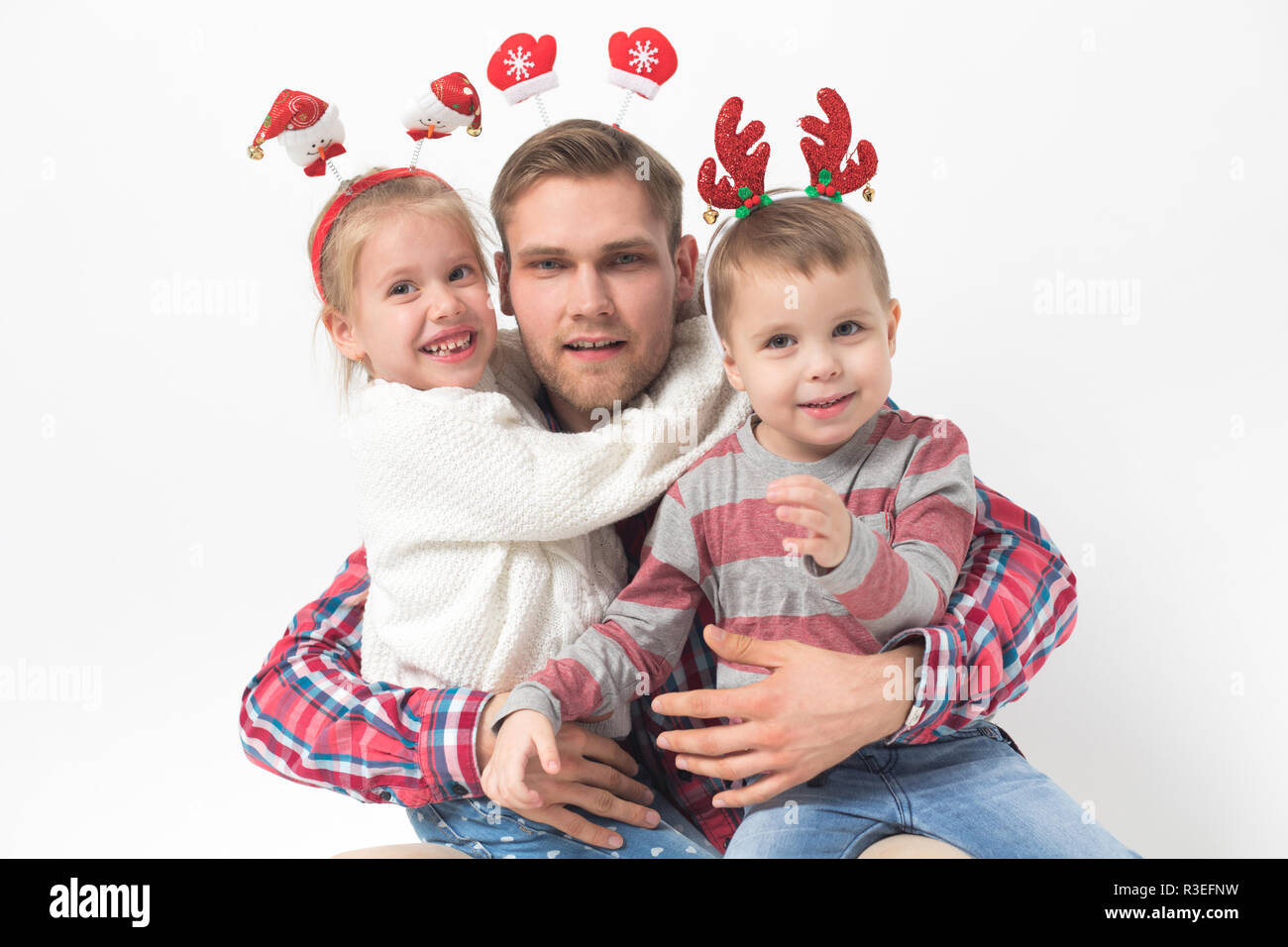 Vater mit Kindern in lustige Weihnachten Stirnbänder auf weißem Hintergrund. Stockfoto