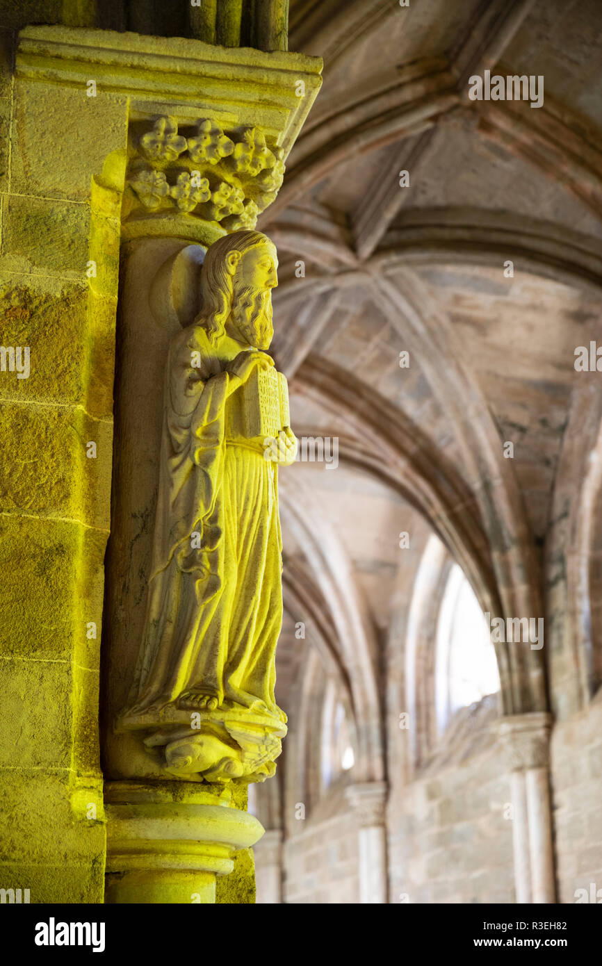 Religiöse Carving im Kreuzgang der Se Evora's Kathedrale beleuchtet durch gelbe Fenster, Evora, Alentejo, Portugal, Europa Stockfoto
