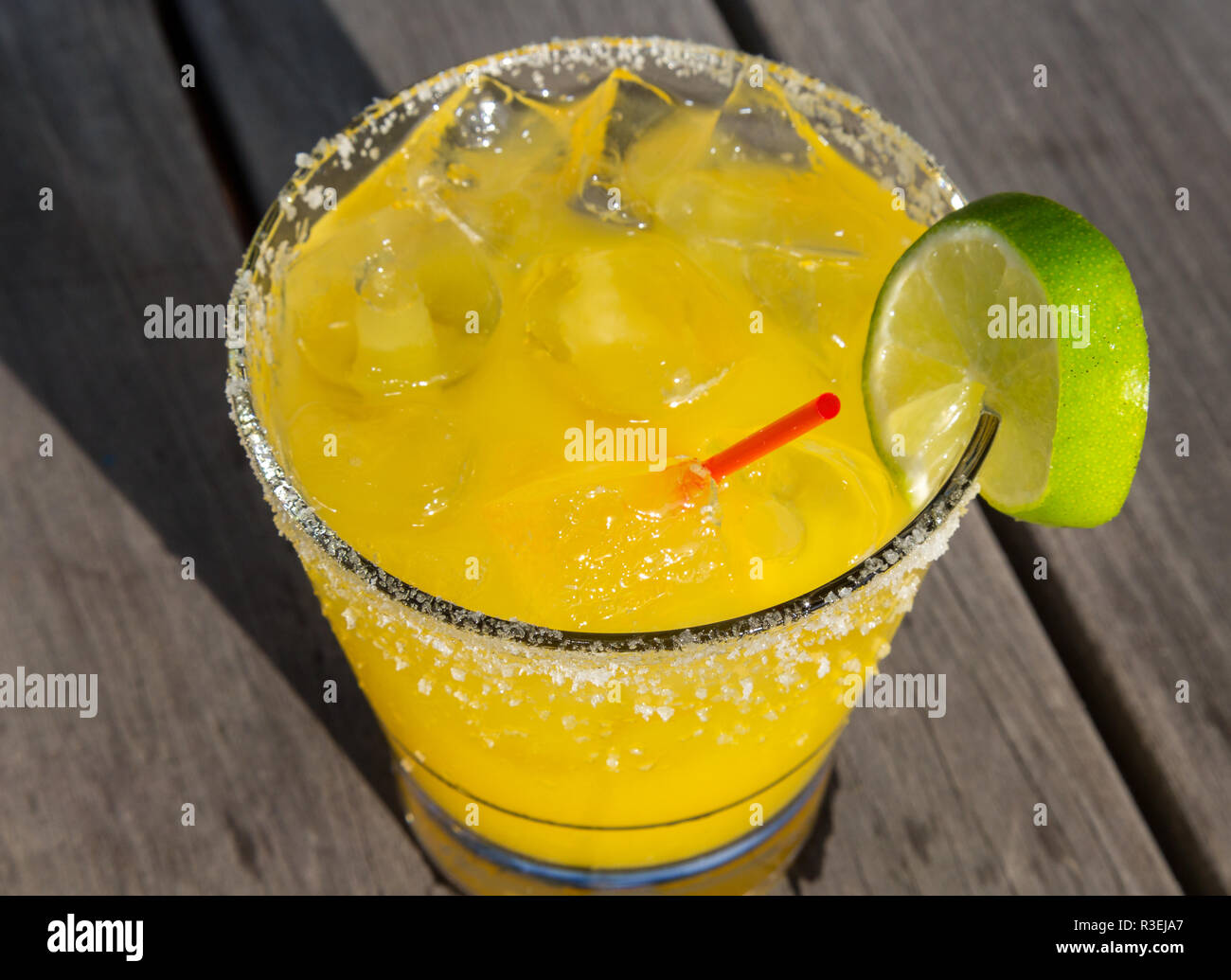 Gelb gefärbte Cocktail mit Salz und Kalk auf der Felge Stockfoto