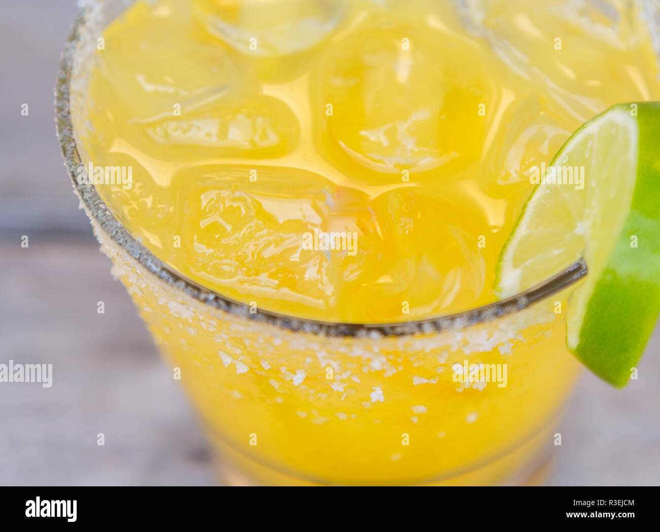 Gelb gefärbte Cocktail mit Salz und Kalk auf der Felge Stockfoto