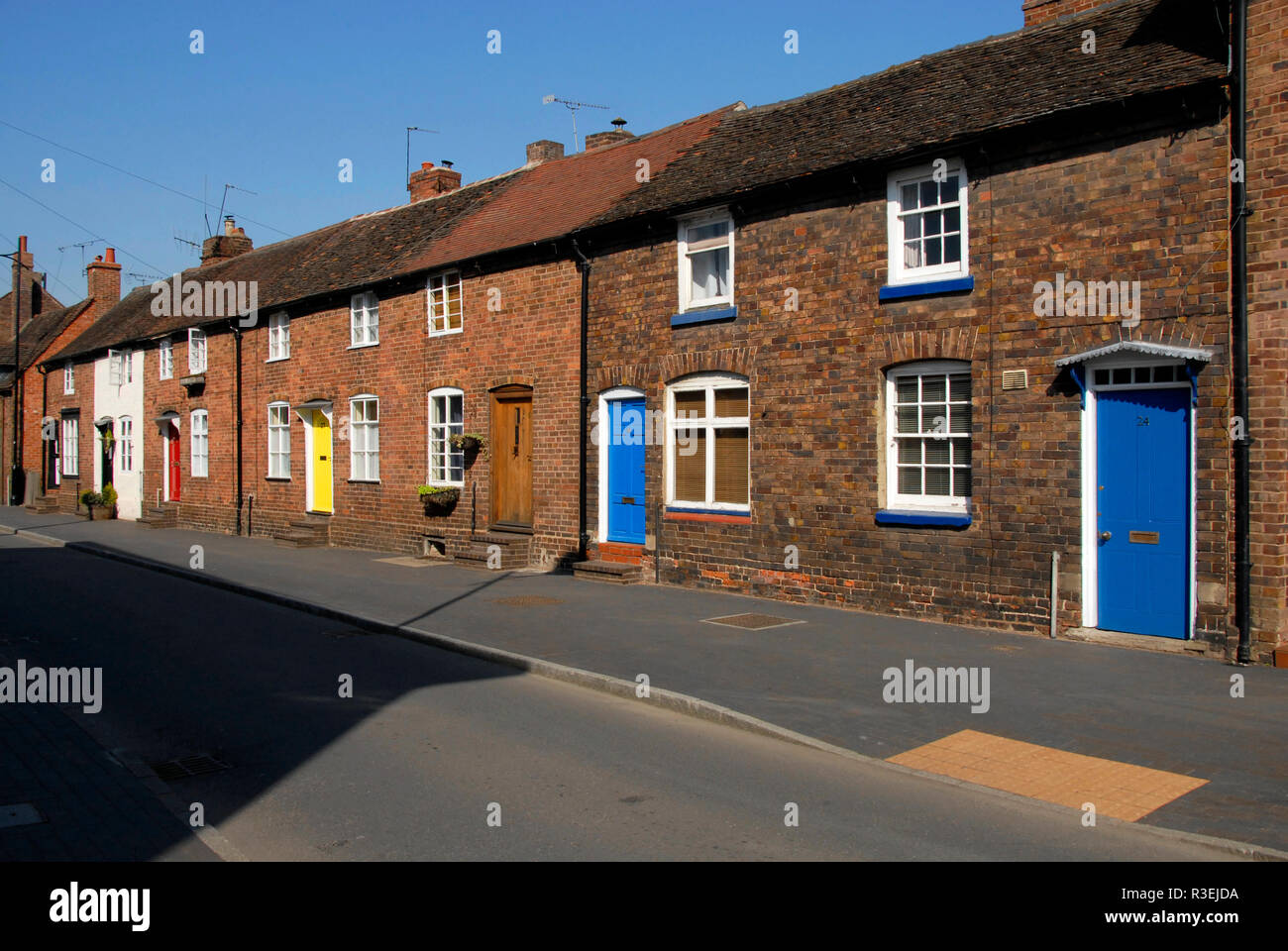 Reihe der attraktive Reihenhäuser mit hell gestrichenen Türen vorne, Bridgnorth, Shropshire, England Stockfoto