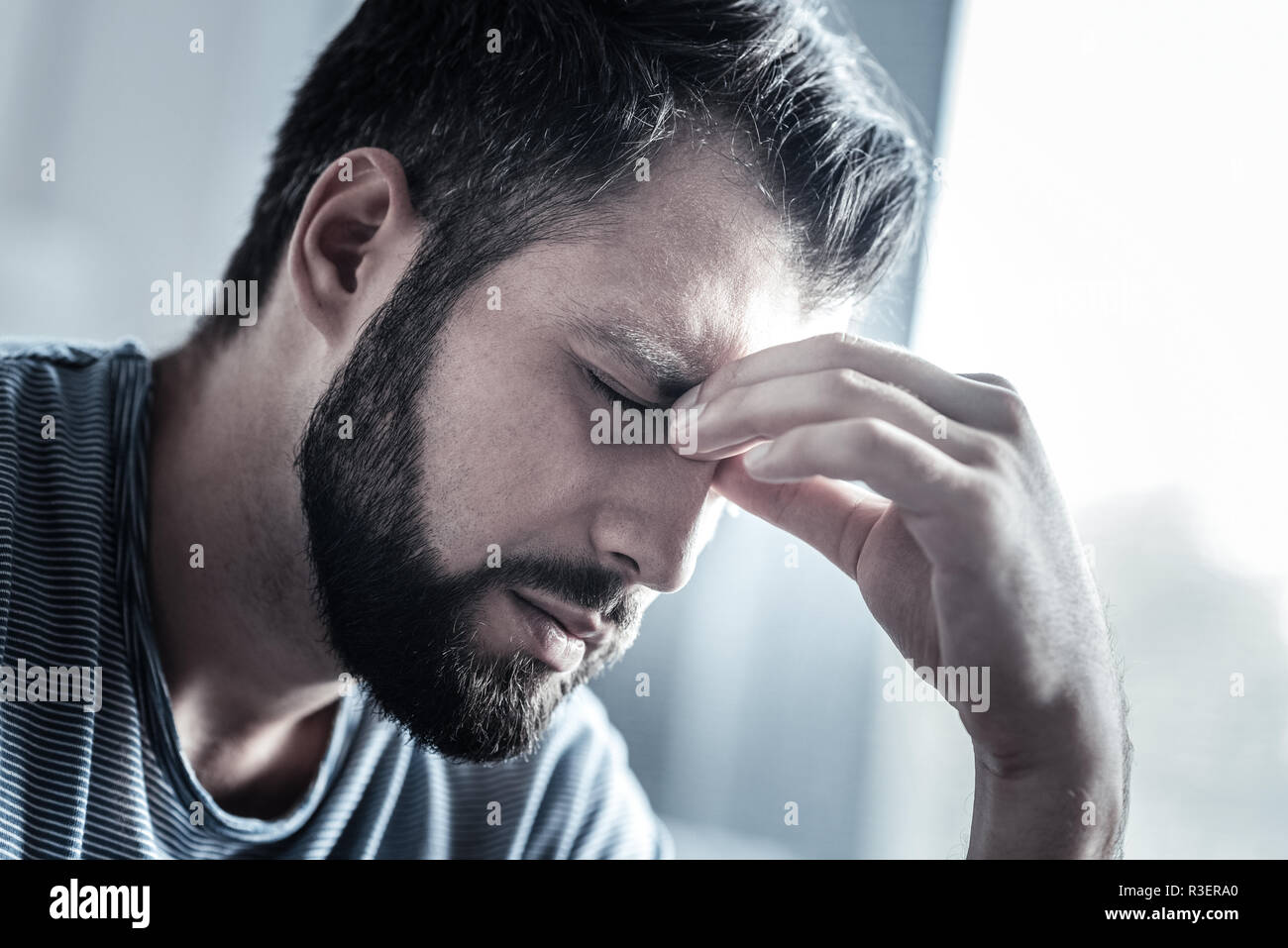 Scharfen Schmerz. Konzentriert brunette halten die Augen geschlossen und den Kopf gebeugt, während mit Kopfschmerzen. Stockfoto