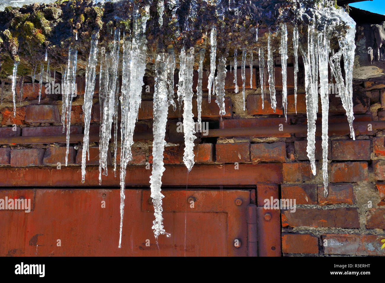 Eiszapfen hängen auf dem Dach in der Nähe bis zu tropfen. Schöne Element der Winter oder Frühling design Stockfoto