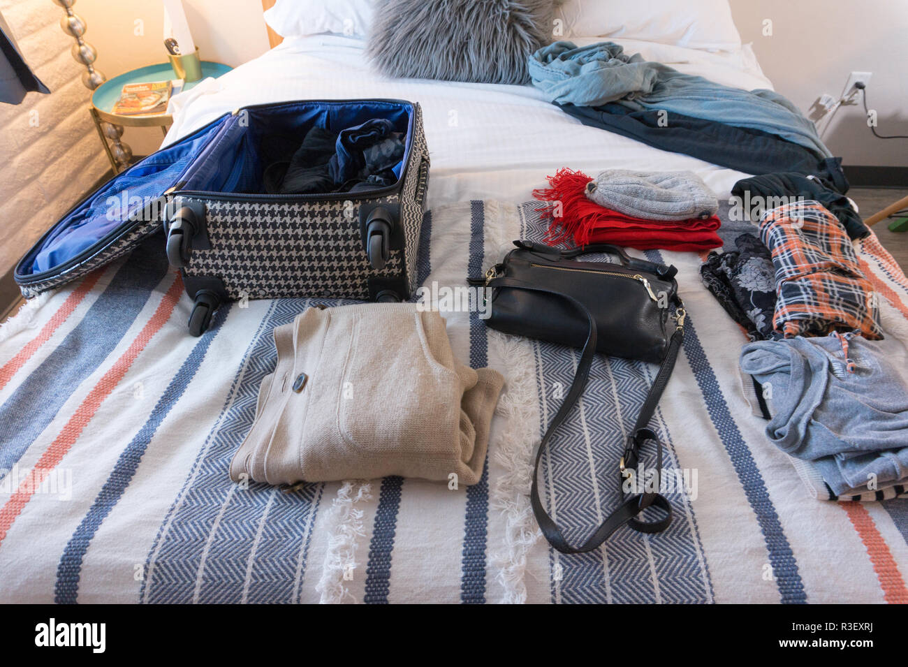 Kleidung und Koffer auf das Bett in hipster Hotelzimmer in USA - bis Verpackung Kleidung der Frau Stockfoto