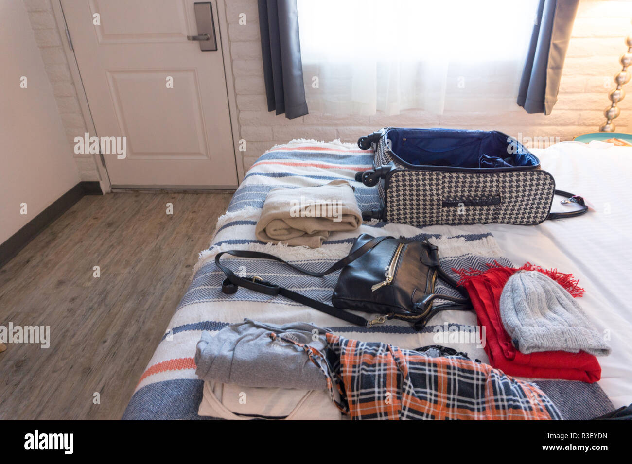 Kleidung und Koffer auf das Bett in hipster Hotelzimmer in USA - bis Verpackung Kleidung der Frau Stockfoto