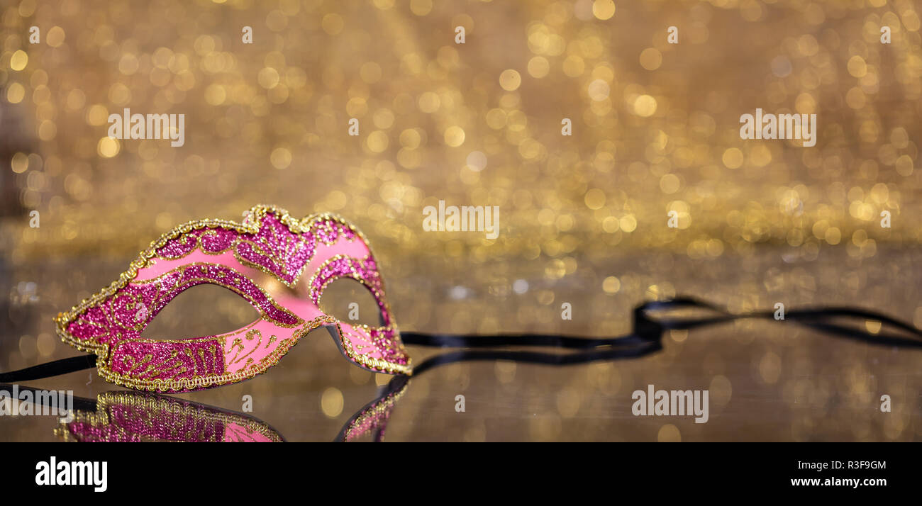 Karneval. Venezianische Maske pink auf goldenen bokeh Hintergrund, Reflexionen, Banner, kopieren Raum Stockfoto