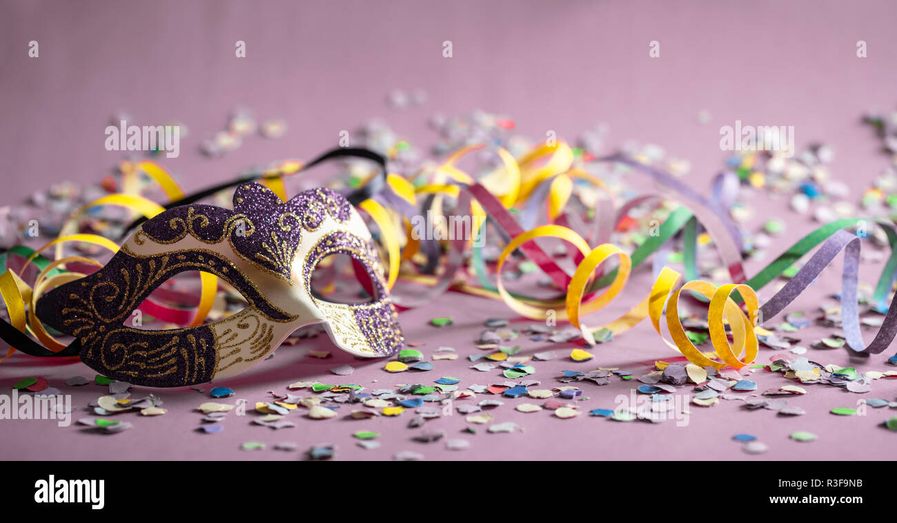 Karneval Party. Purple gold Maske, Luftschlangen und Konfetti auf Pastell  rosa Hintergrund, Banner Stockfotografie - Alamy