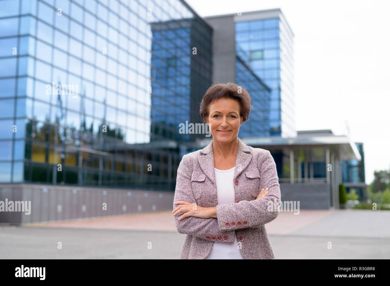 Gerne Reife Geschäftsfrau, Lächeln gegen den Blick auf die Stadt Stockfoto