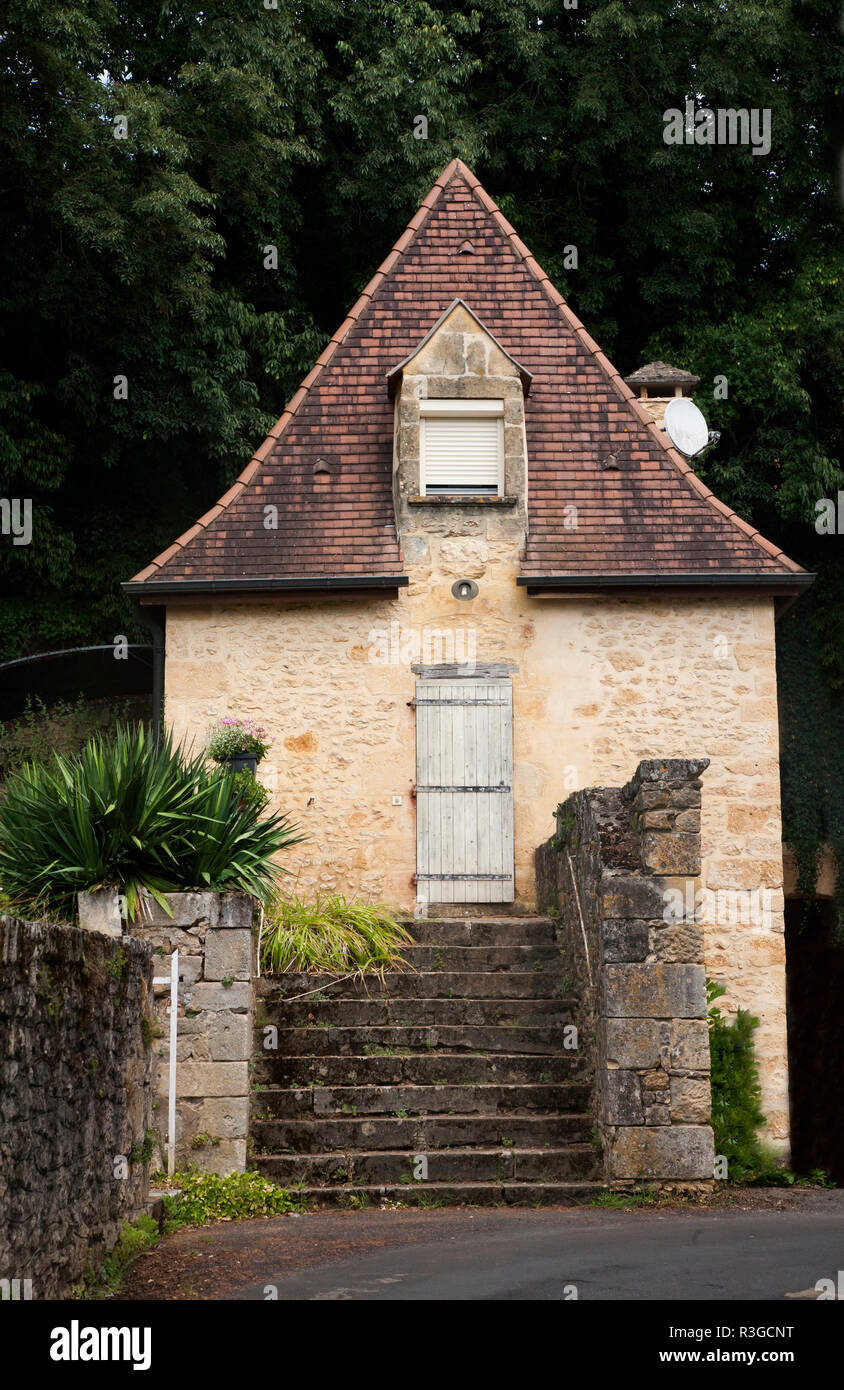 Im traditionellen Stil aus Stein gebaute Haus mit einem Wald dahinter, in der Dordogne, Frankreich Stockfoto