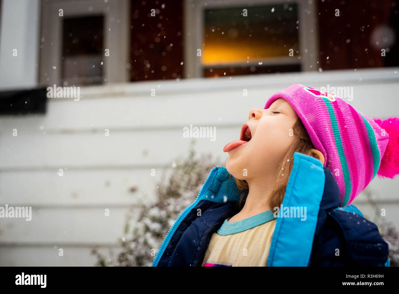 4-Jähriges Mädchen Fänge Schnee auf der Zunge bei einem Sturm in den USA im November. Stockfoto