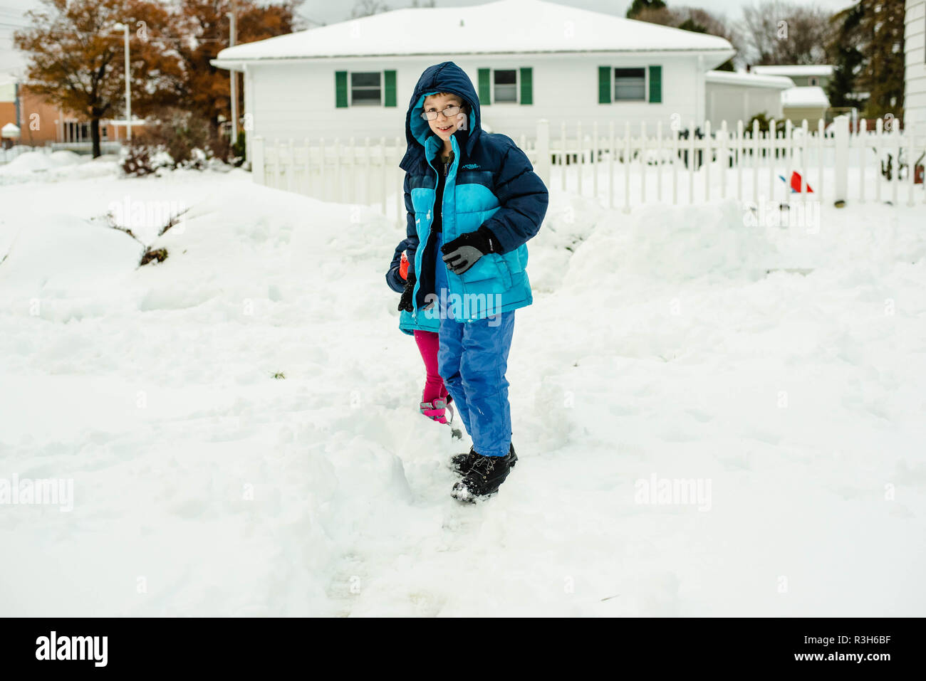 Geschwister, ein Junge und ein Mädchen, Spielen im Schnee An einem kalten Wintertag in den Vereinigten Staaten. Stockfoto