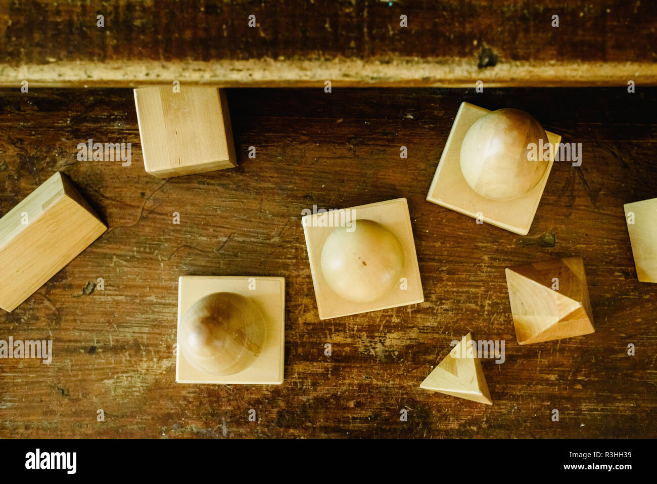 Massivholz formen Geometrie und Volumes, Kegel, Dreiecke, Quadrate zu studieren, Kugeln auf einem warmen Holz Hintergrund. Stockfoto