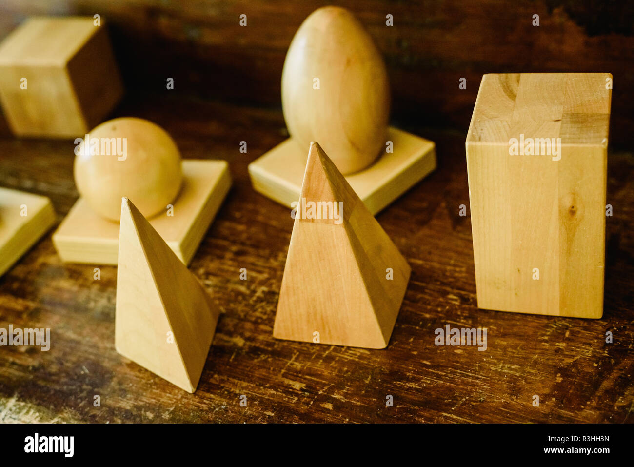 Massivholz formen Geometrie und Volumes, Kegel, Dreiecke, Quadrate zu studieren, Kugeln auf einem warmen Holz Hintergrund. Stockfoto