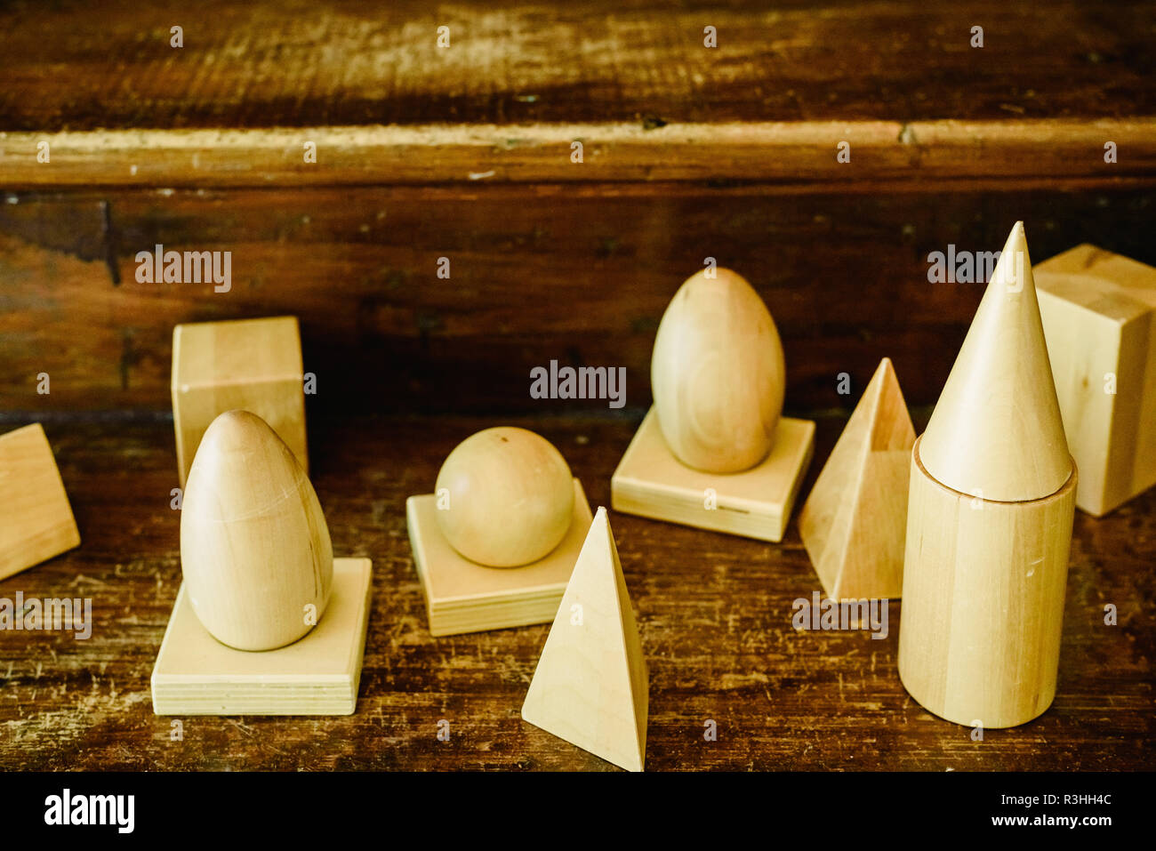 Massivholz formen Geometrie und Volumes, Kegel, Dreiecke, Quadrate zu studieren, Kugeln auf einem warmen Holz Hintergrund. Stockfoto