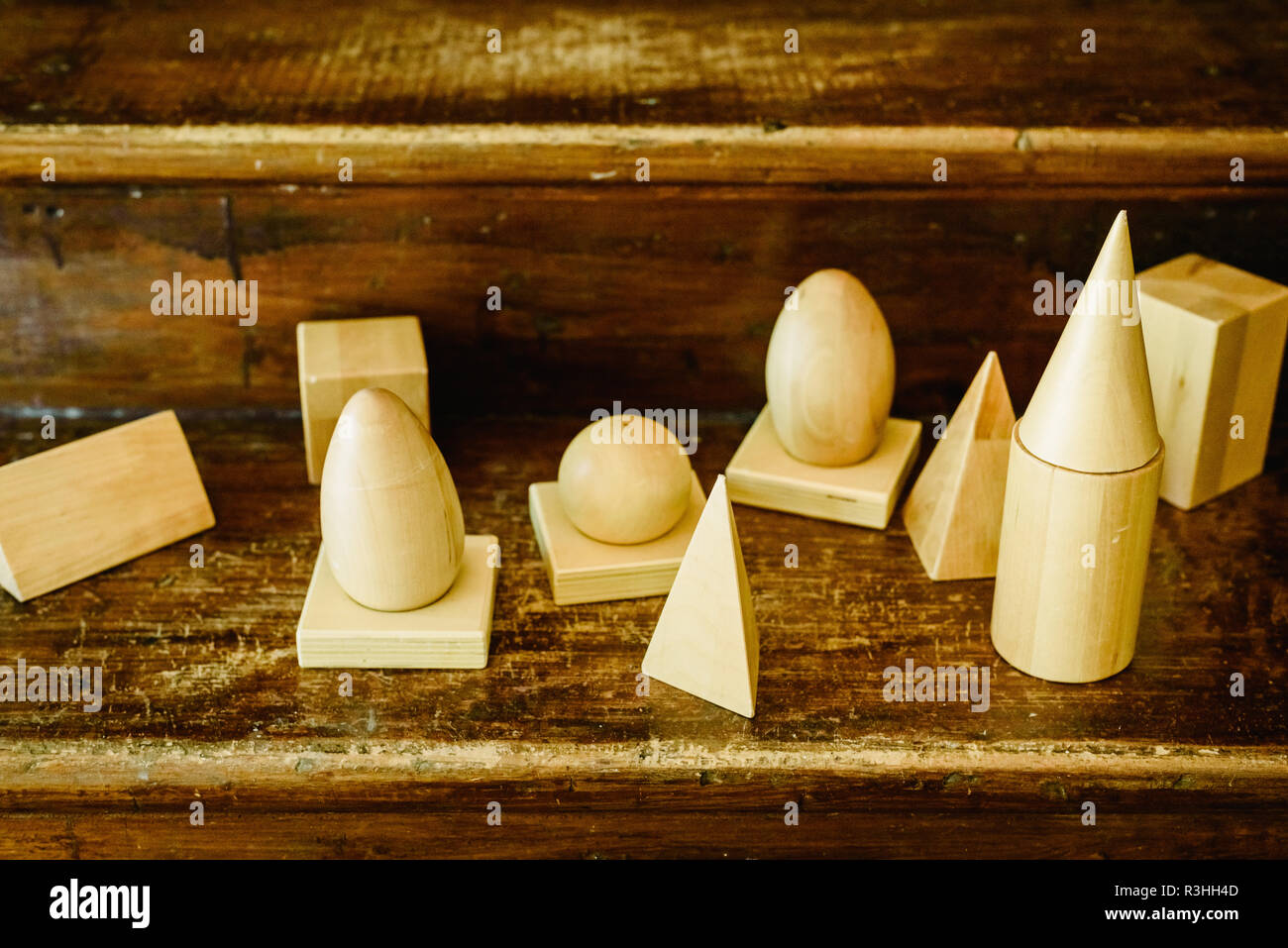 Massivholz formen Geometrie und Volumes, Kegel, Dreiecke, Quadrate zu studieren, Kugeln auf einem warmen Holz Hintergrund. Stockfoto