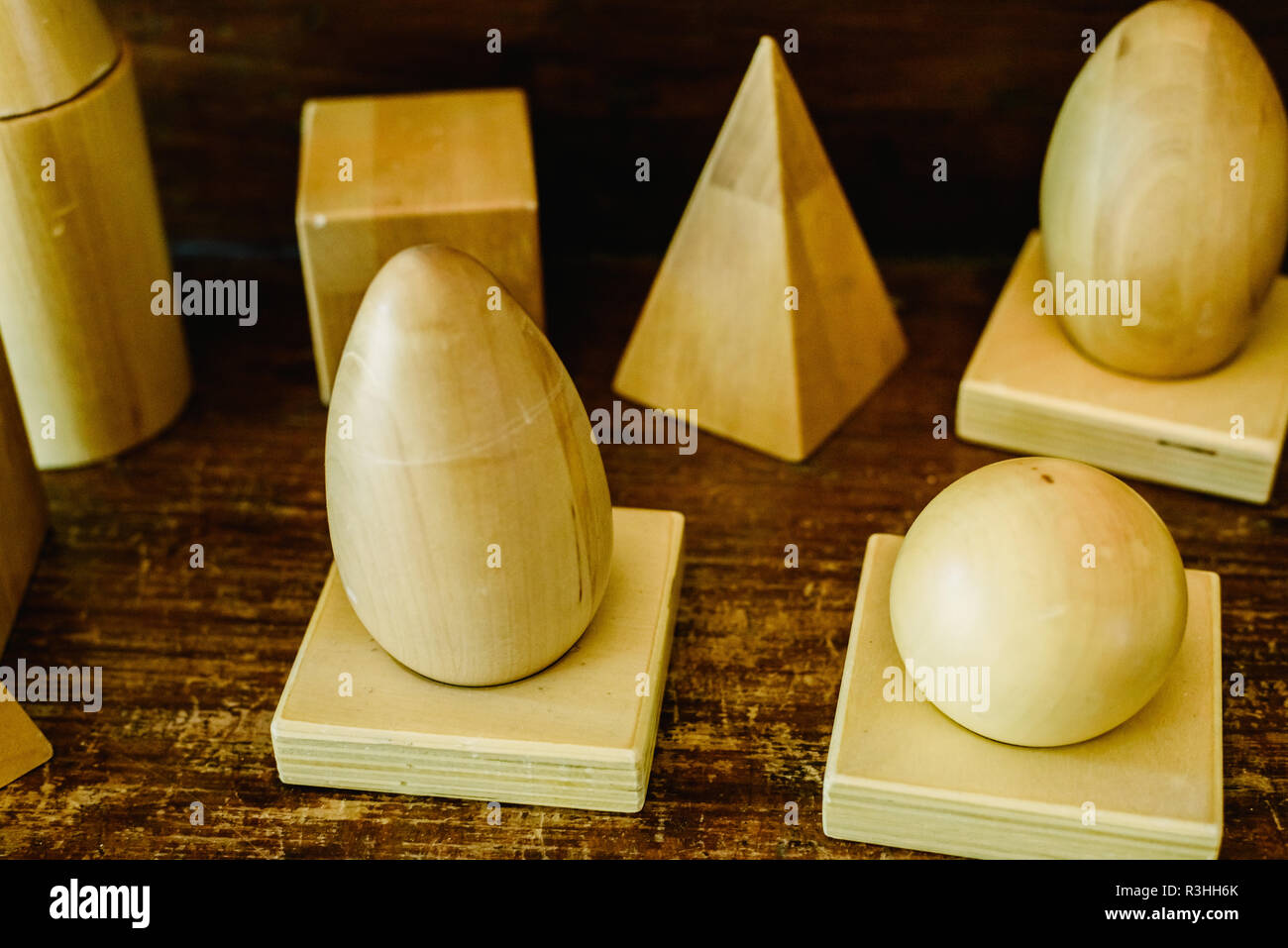 Massivholz formen Geometrie und Volumes, Kegel, Dreiecke, Quadrate zu studieren, Kugeln auf einem warmen Holz Hintergrund. Stockfoto