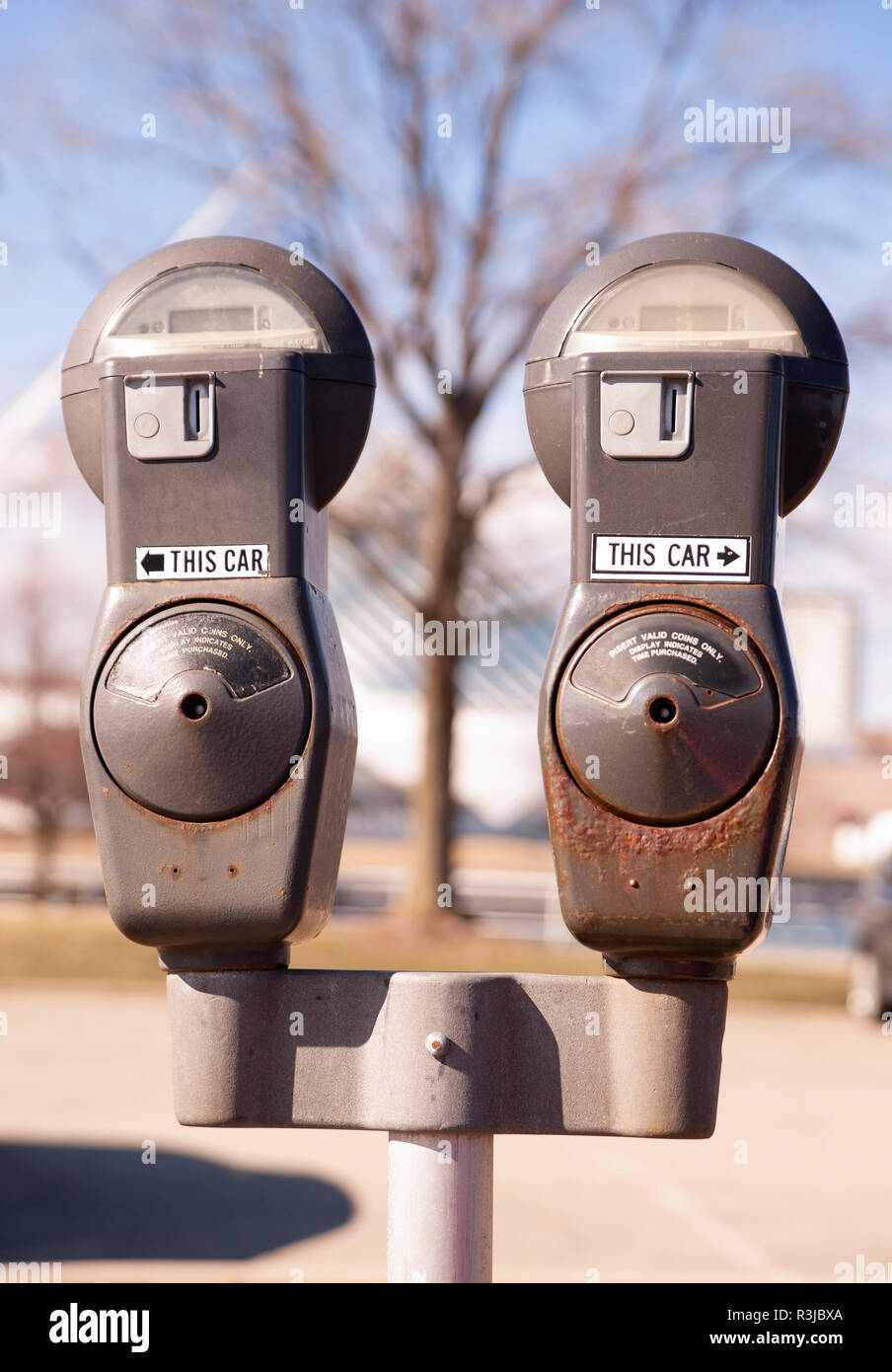 Ein Pole mit zwei münzbetriebene Parkuhren steht im Winter auf der Straße Stockfoto