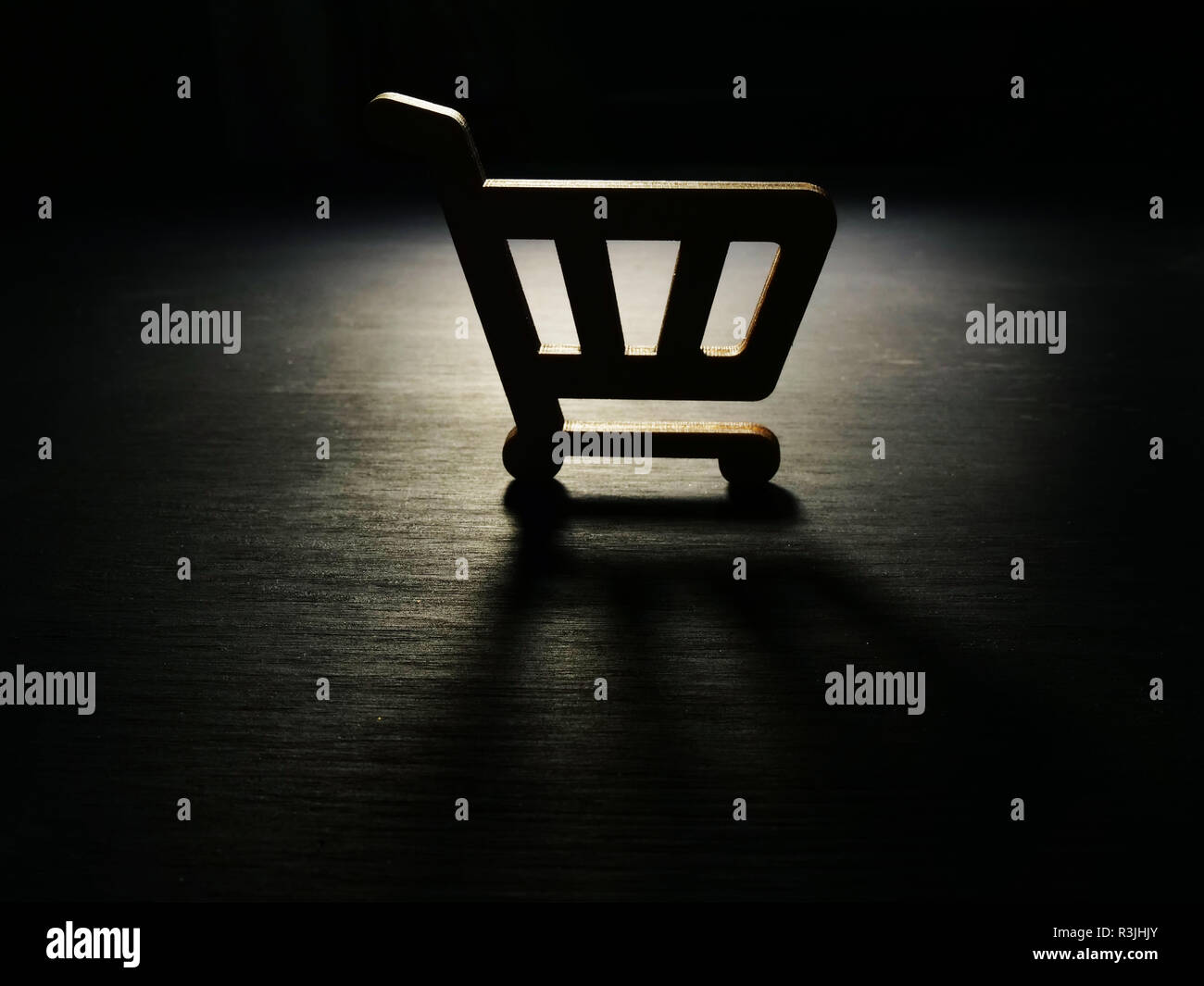 Konsumismus Konzept. Modell der Warenkorb in der Dunkelheit. Stockfoto