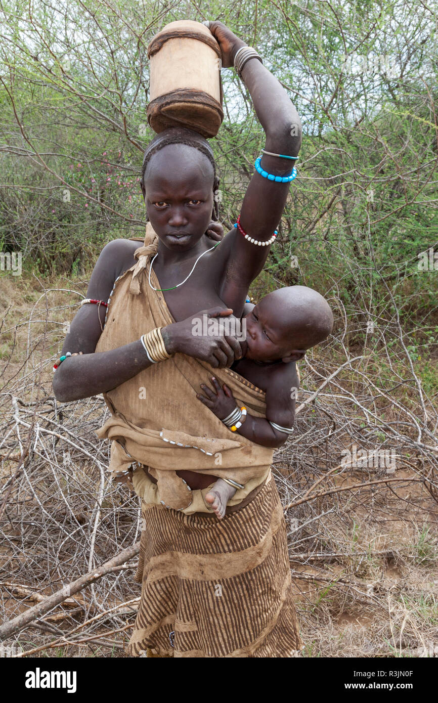 Afrika Athiopien Sudlichen Omo Valley Mursi Stamm Ein Mursi Frau Stillen Ihr Baby Und Eine Schaufel Auf Den Kopf Stockfotografie Alamy