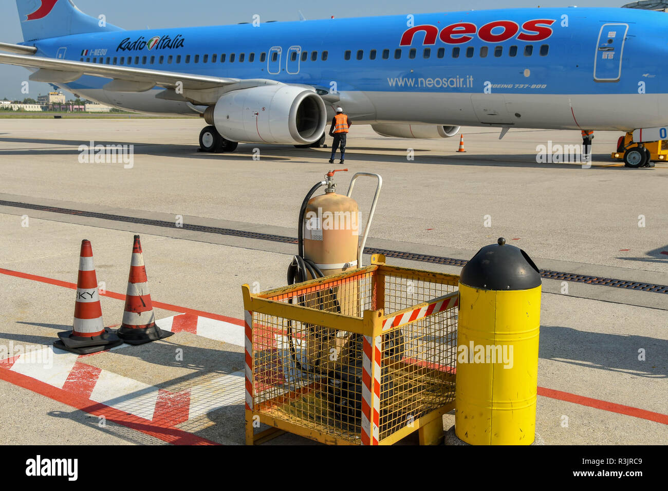 Boden Sicherheitsausrüstung auf dem Flughafenvorfeld in Verona, Italien. Eine Boeing 737 ist im Hintergrund. Stockfoto