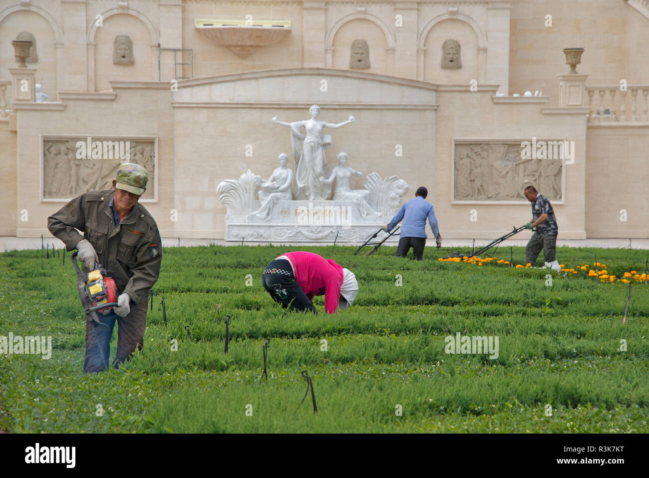 China, Provinz Xinjiang, Shihezi. Arbeitnehmer Trimmen der Landschaft bei changyu Chateau Baron Balboa in Xinjiang Uigurischen Autonomen Region. Stockfoto