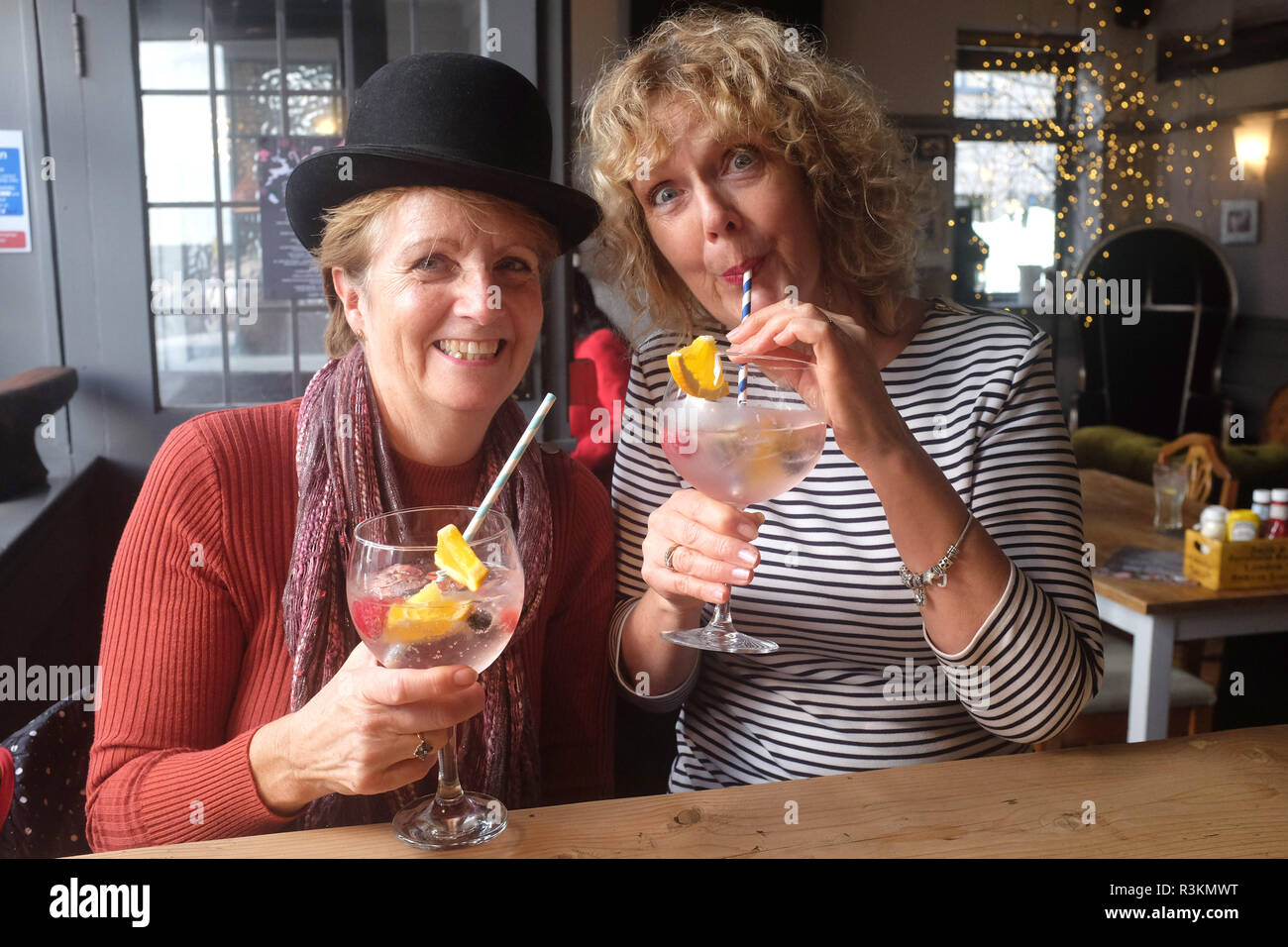 Frauen eine getragen eine Melone in der Cobb Arme trinken eine große Gin und Tonic mit Papier Trinkhalme UK Stockfoto