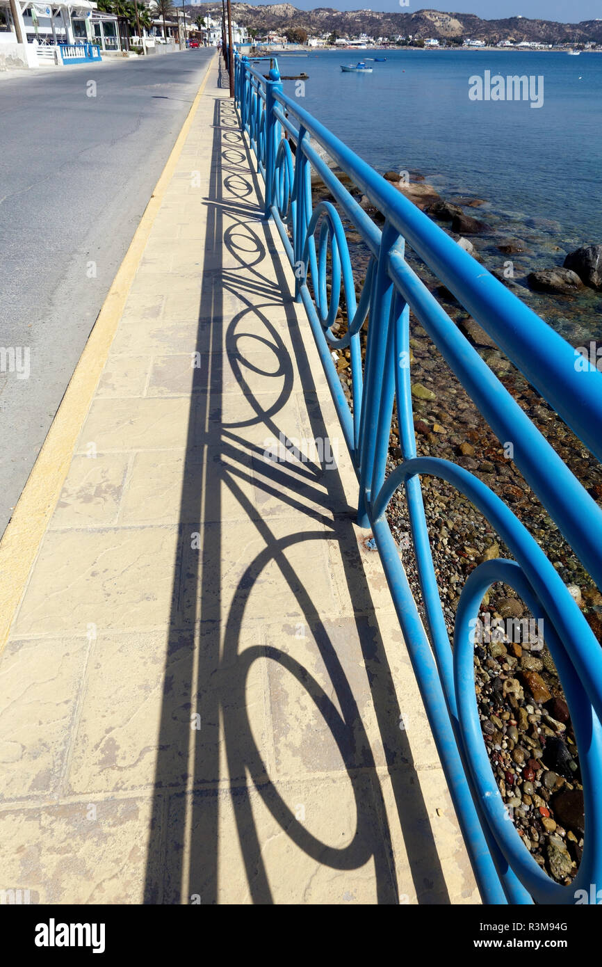 Geländer und Schatten entlang der Promenade in Kefalos auf der griechischen Insel Kos Stockfoto
