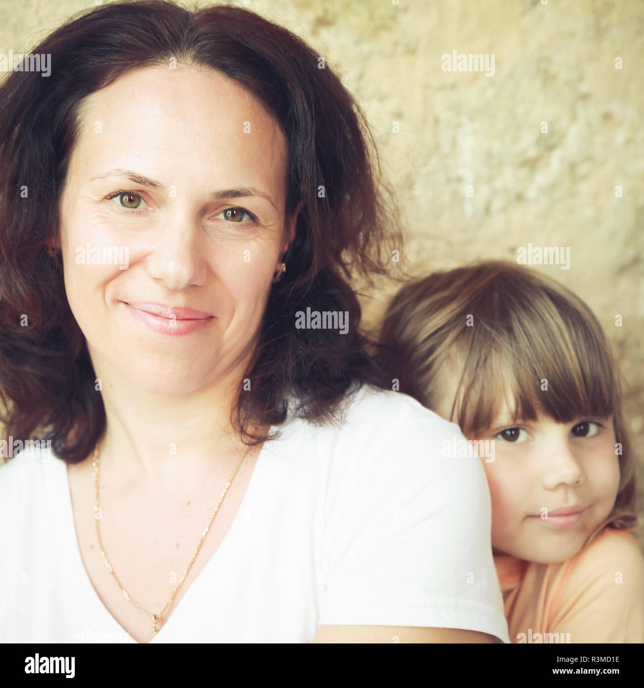 Lächelnden jungen Erwachsenen weißen Mutter mit ihrer kleinen Tochter, Nahaufnahme portrait. Vintage stilisierte square Foto mit Tonwertkorrektur Filterwirkung, ich Stockfoto