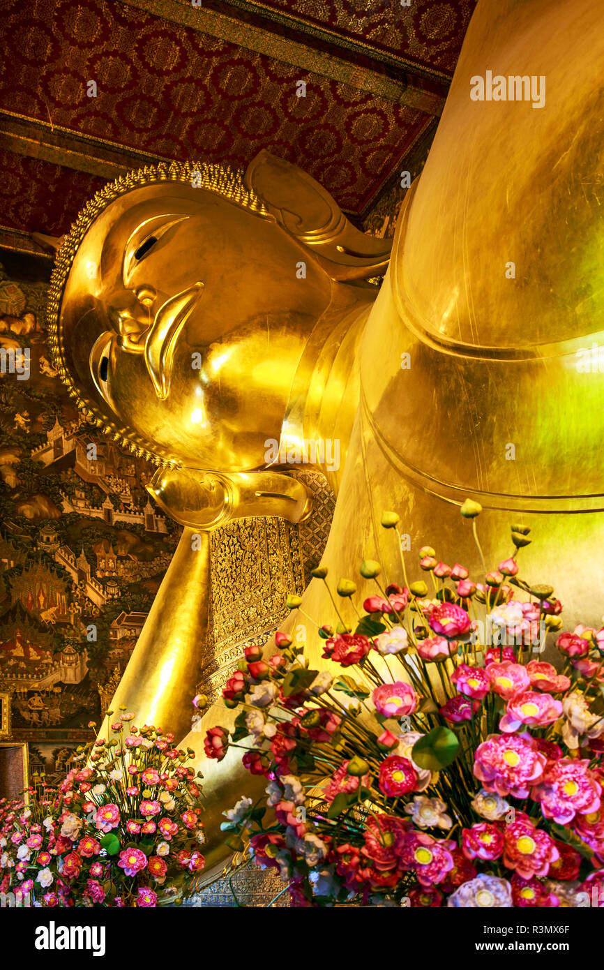 Bangkok, Thailand. Riesige liegende Gold Buddha Statue von Blumen im Wat Pho Tempel gerahmt Stockfoto