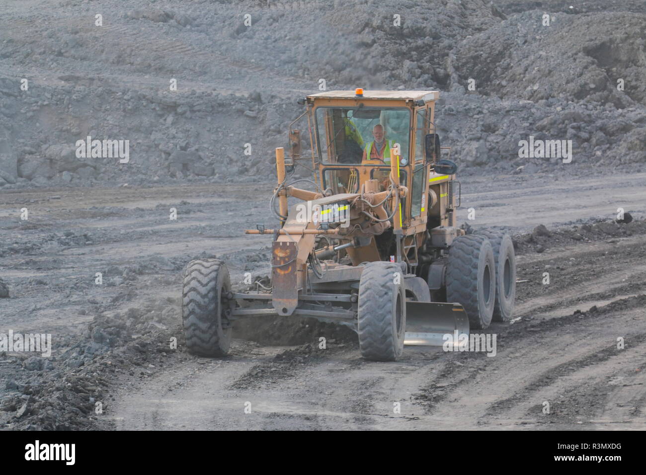 Ein Caterpillar 14G Grader bei der Arbeit auf der Recycoal, Kohle Recycling Website in Rossington, Doncaster, die für die Pflege der Website haul Straßen verwendet wird. Stockfoto