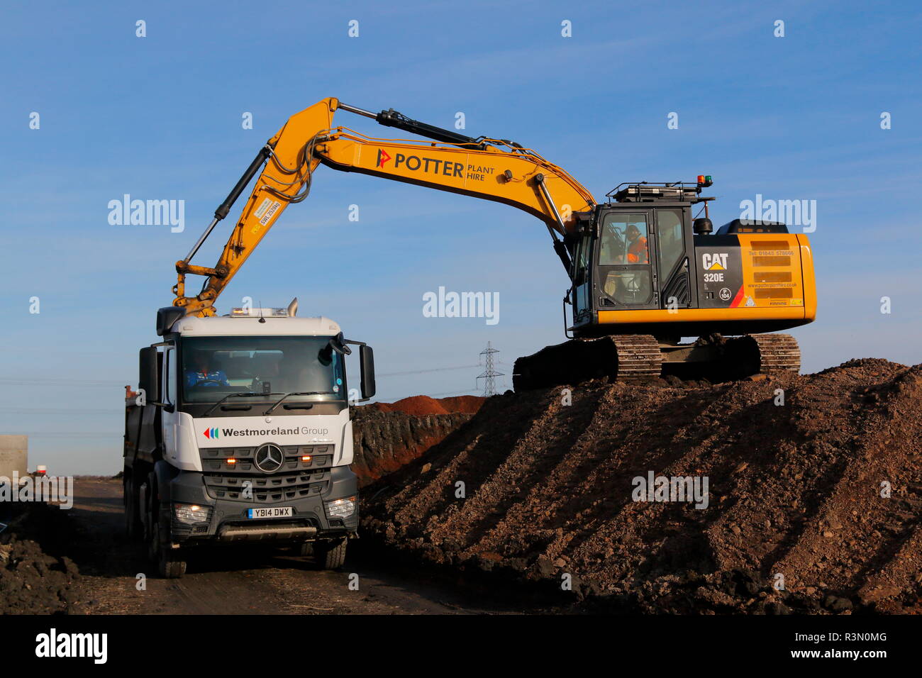 Ein Caterpillar 320E Beladen von Lkws auf der FARRRS Link Road in Rossington, Doncaster, die jetzt als die großen Yorkshire Weise bekannt Stockfoto