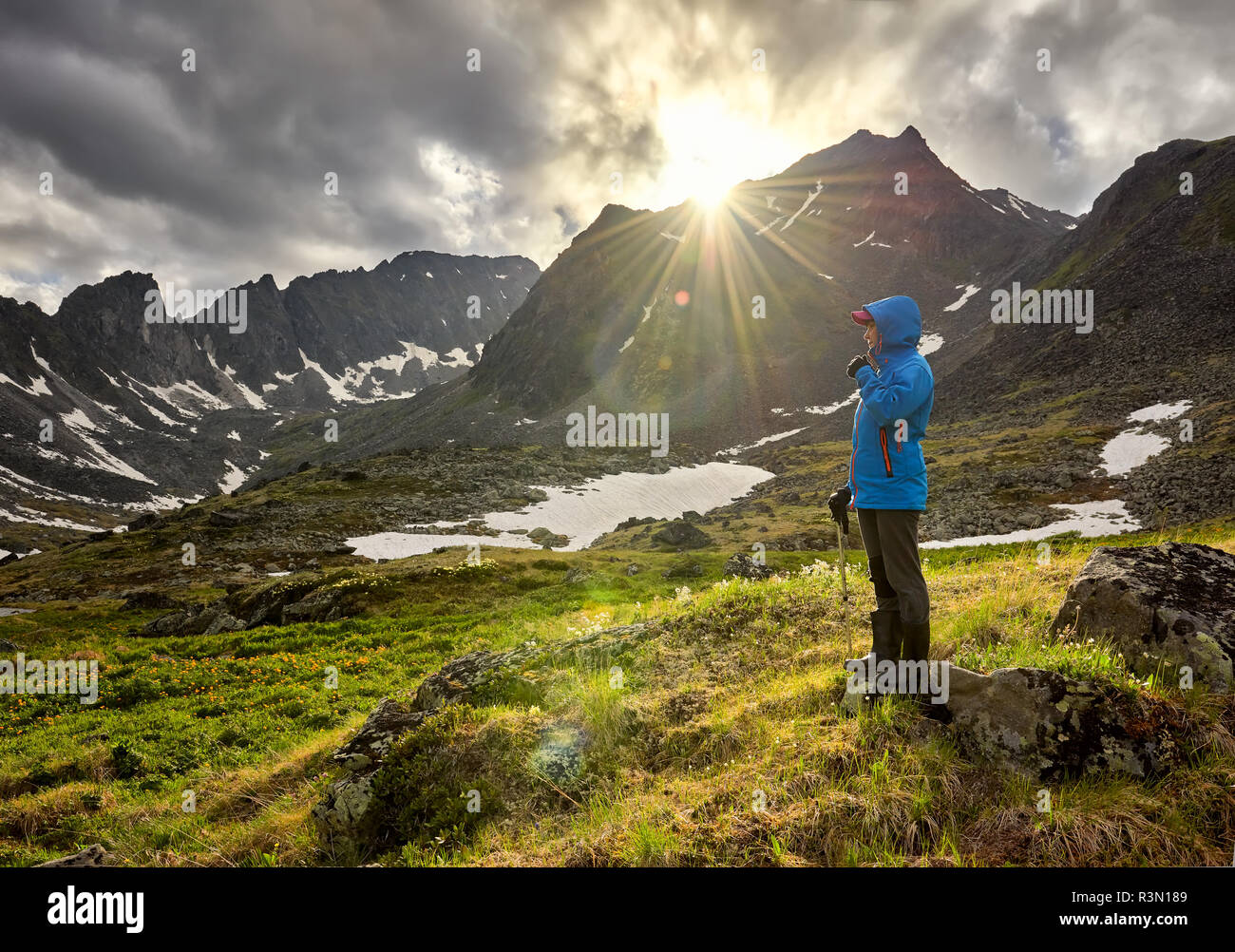 Pass hopping. Frau steht am Damm in Berg Tundra an kalten Morgen. Die Strahlen der Sonne schön Platz beleuchten neben Mädchen Stockfoto