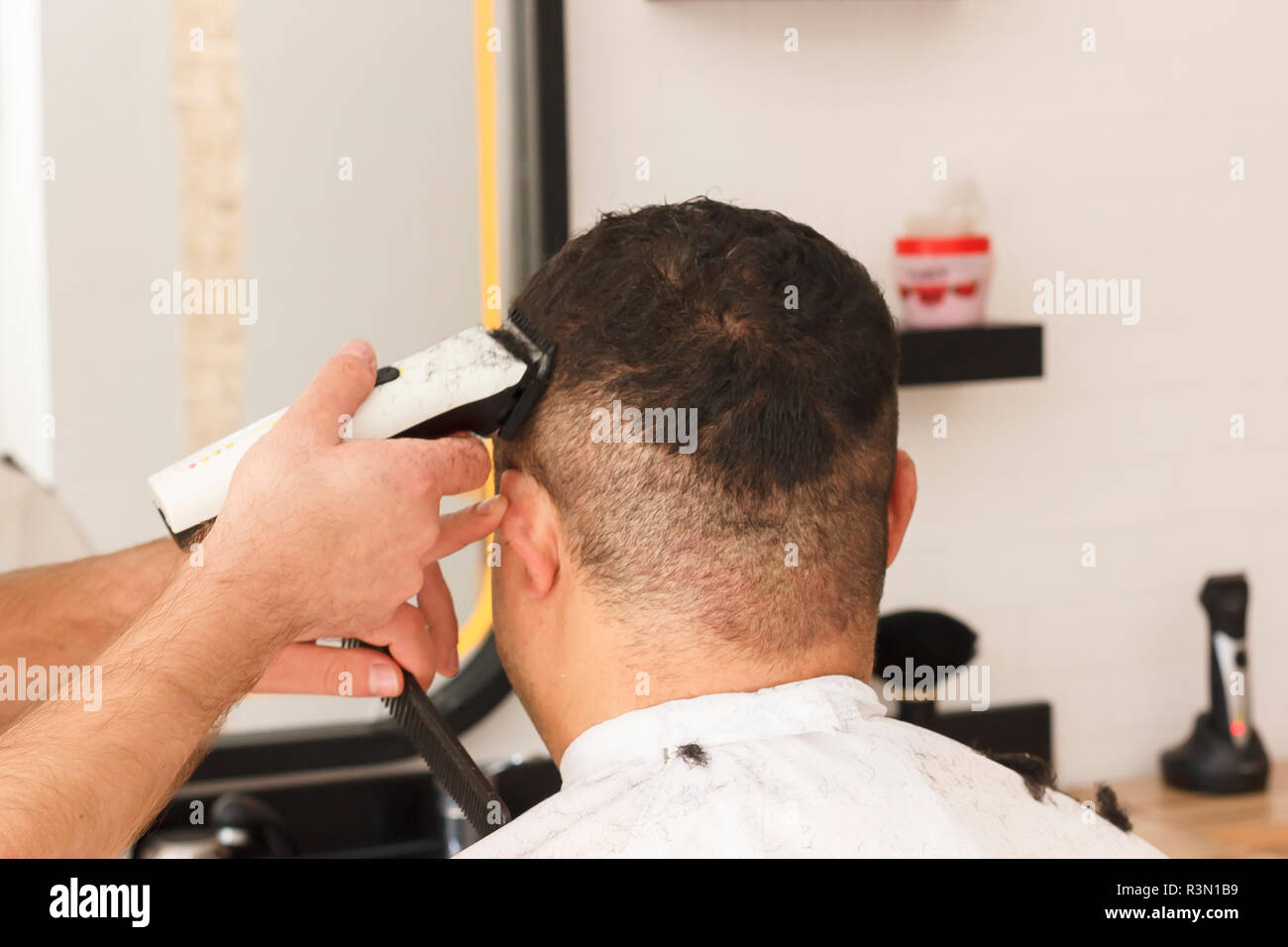 Rückansicht des Menschen immer kurze Haare schneiden mit Friseur mit einem  haarschneider Maschine Stockfotografie - Alamy