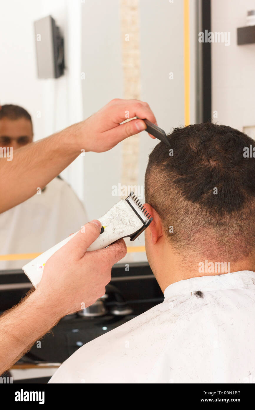 Rückansicht des Menschen immer kurze Haare schneiden mit Friseur mit einem  haarschneider Maschine Stockfotografie - Alamy