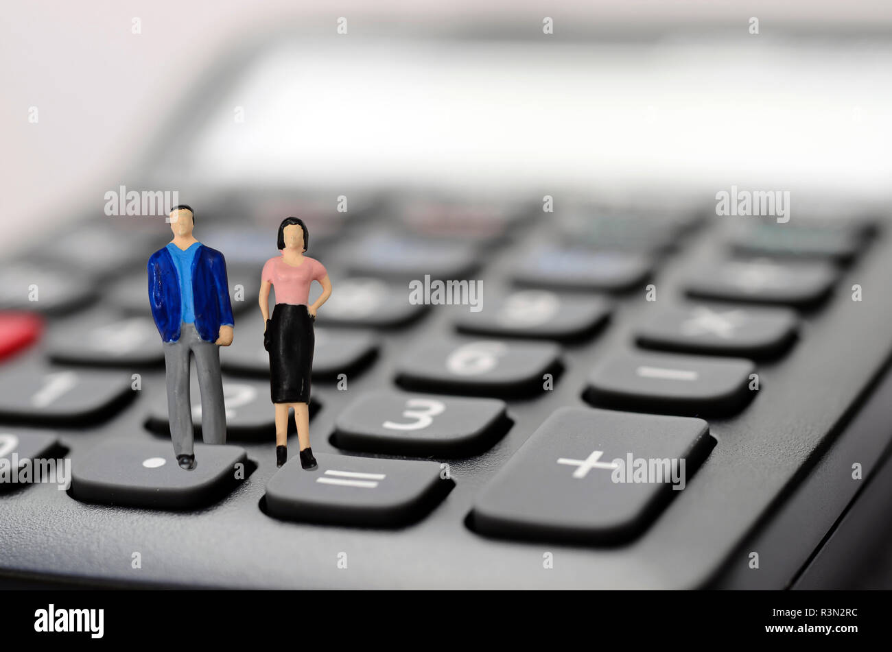 Mann und Frau stehen auf Rechner für Kaufkraft Abbildung Stockfoto