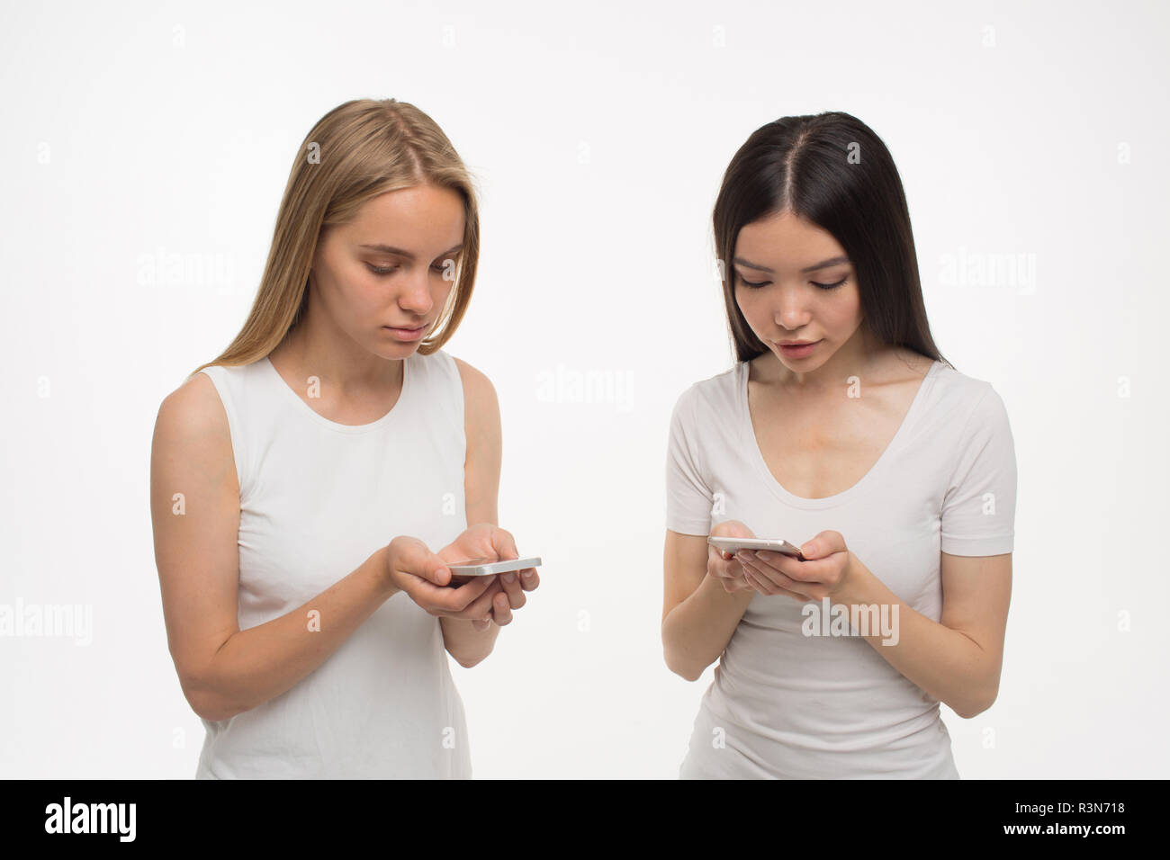 Zwei Frauen die Abhängigkeit auf dem Smartphone Stockfoto
