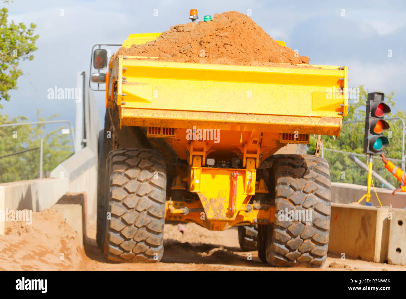 Ein Knickgelenkter Dumper drückt über einem schmalen Eisenbahnbrücke über den Bau von Iport in Rossington, Doncaster, South Yorkshire. Stockfoto