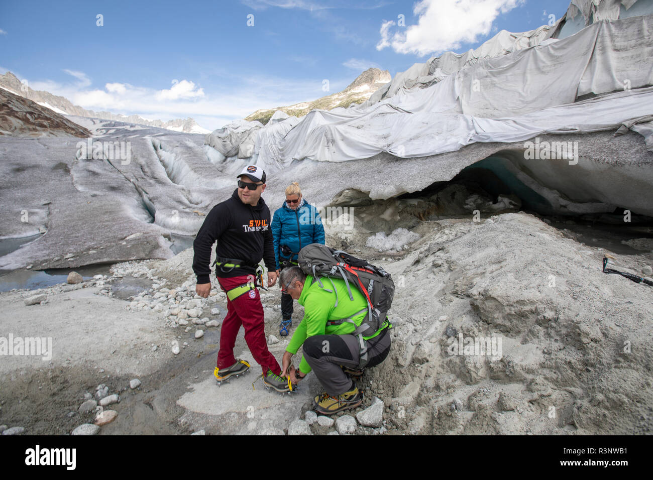 Alfredo hoch (grüne Jacke) und seine Frau Anja Behrens machen sich zusammen  mit ihrem Freund Ronny Miestas auf den Rohone-Gletscher bereit. Riesige  Laken mit Fleece-Decken, die einen Eistunnel an der Mündung des