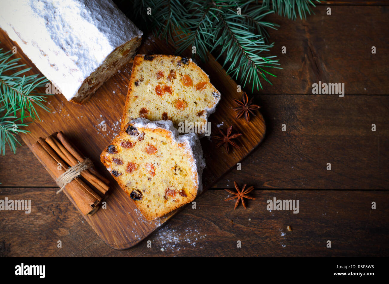 Obst Brot Kuchen mit Puderzucker bestäubt, Weihnachten und Winter Urlaub gönnen, hausgemachte Kuchen mit Rosinen auf hölzernen Hintergrund Stockfoto
