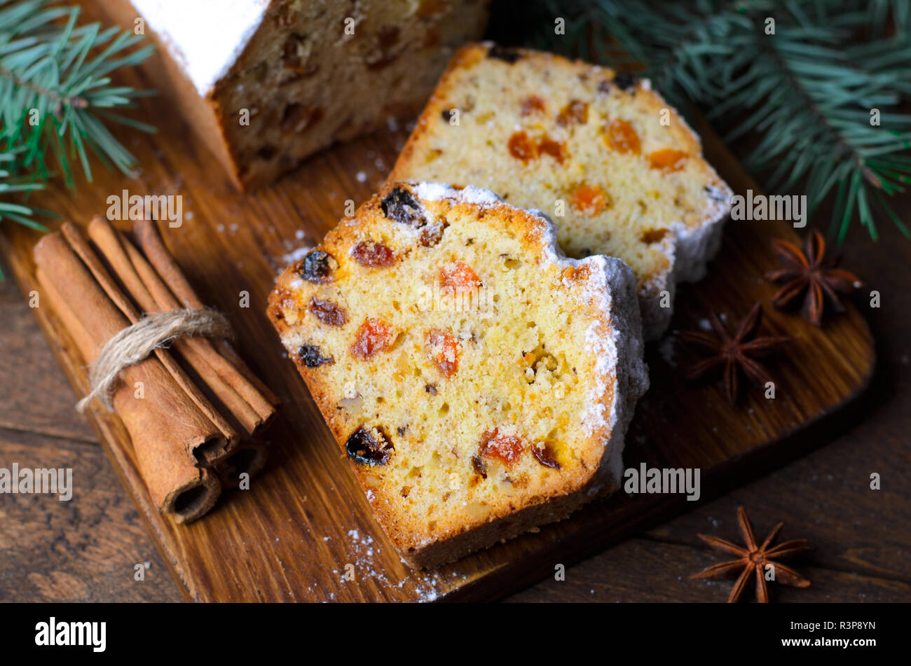 Obst Brot Kuchen mit Puderzucker bestäubt, Weihnachten und Winter Urlaub gönnen, hausgemachte Kuchen mit Rosinen auf hölzernen Hintergrund Stockfoto