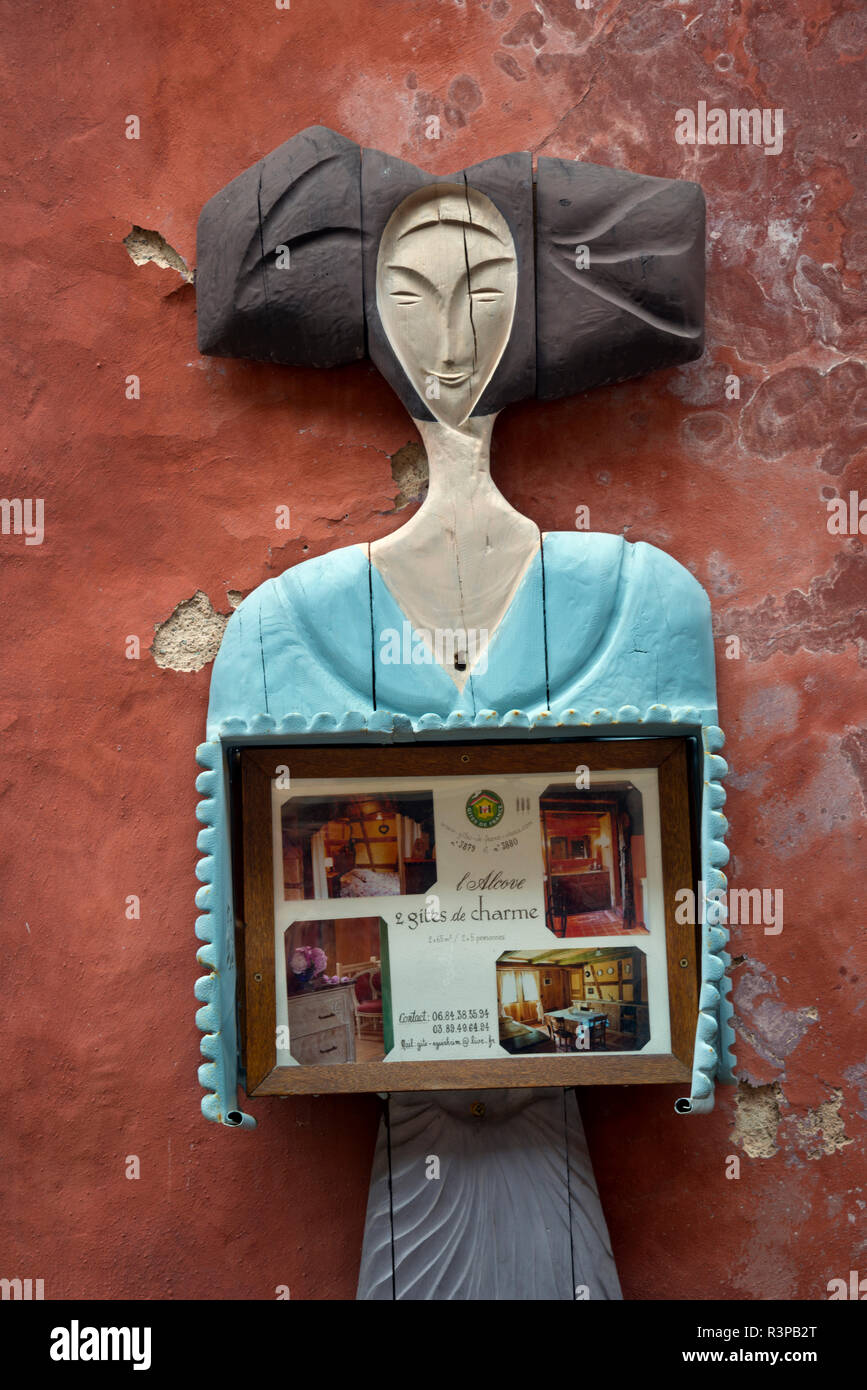 Die Europäische Union, Frankreich, Elsass, Eguisheim Dorf. Holz- Zeichen einer Frau mit Fotos von den Zimmern in der kleinen Pension zur Verfügung. Stockfoto