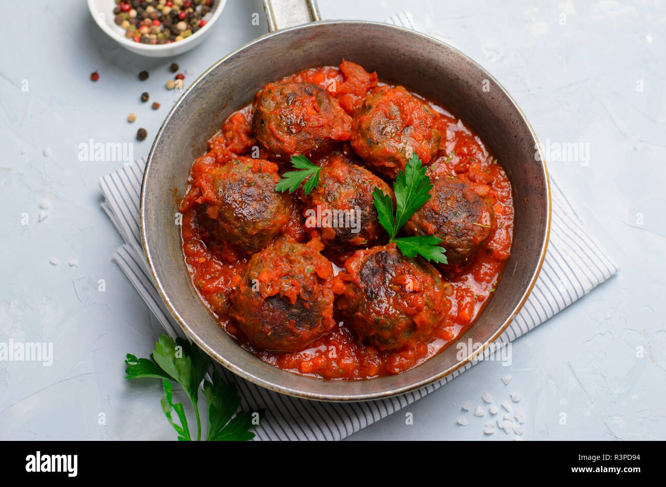 Frikadellen in Tomatensoße in einer Pfanne auf einem hellen Hintergrund ...