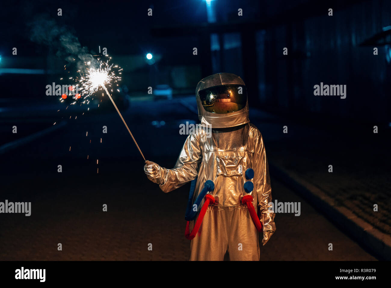 Spaceman stehen draußen in der Nacht holding Sparkler Stockfoto