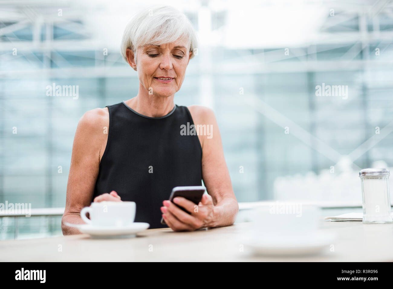 Ältere Frau mit Handy in ein Cafe Stockfoto