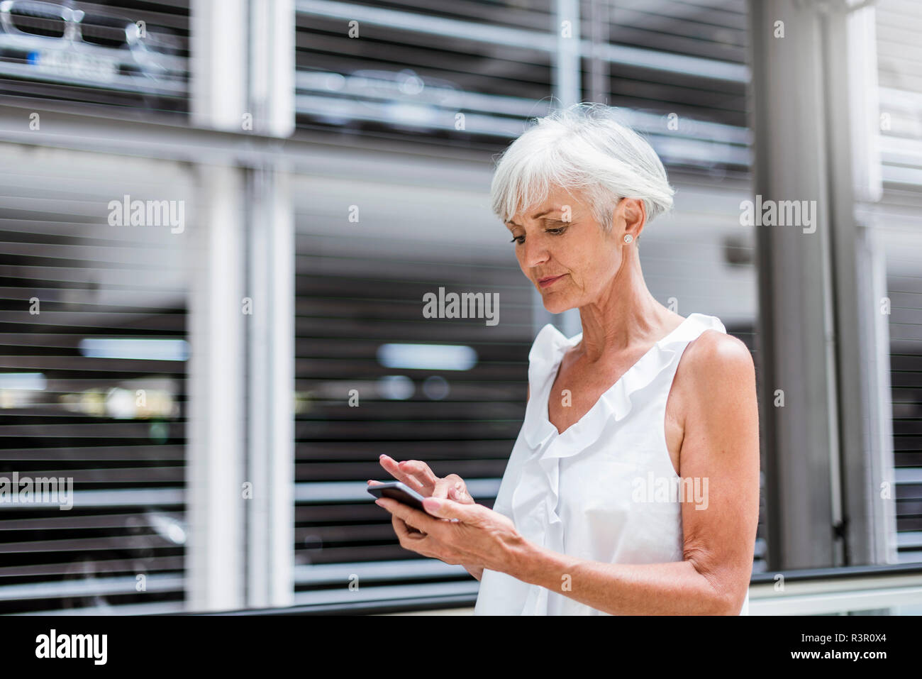 Ältere Frau mit Handy im Freien Stockfoto