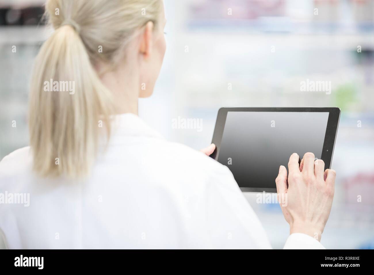 Weibliche Apotheker mit digitalen Tabletten in der Apotheke. Stockfoto